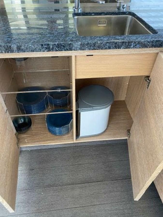 a kitchen counter with a sink and a shelf with bowls aboard THE ONLY BLUE 66 FLY Yacht for Sale