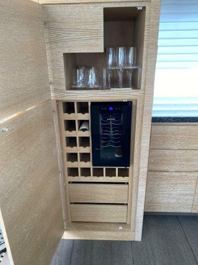 a wooden cabinet with a glass door aboard THE ONLY BLUE 66 FLY Yacht for Sale