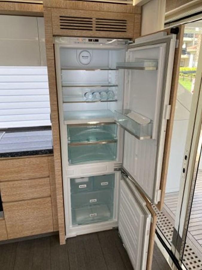 an empty refrigerator in a kitchen aboard THE ONLY BLUE 66 FLY Yacht for Sale