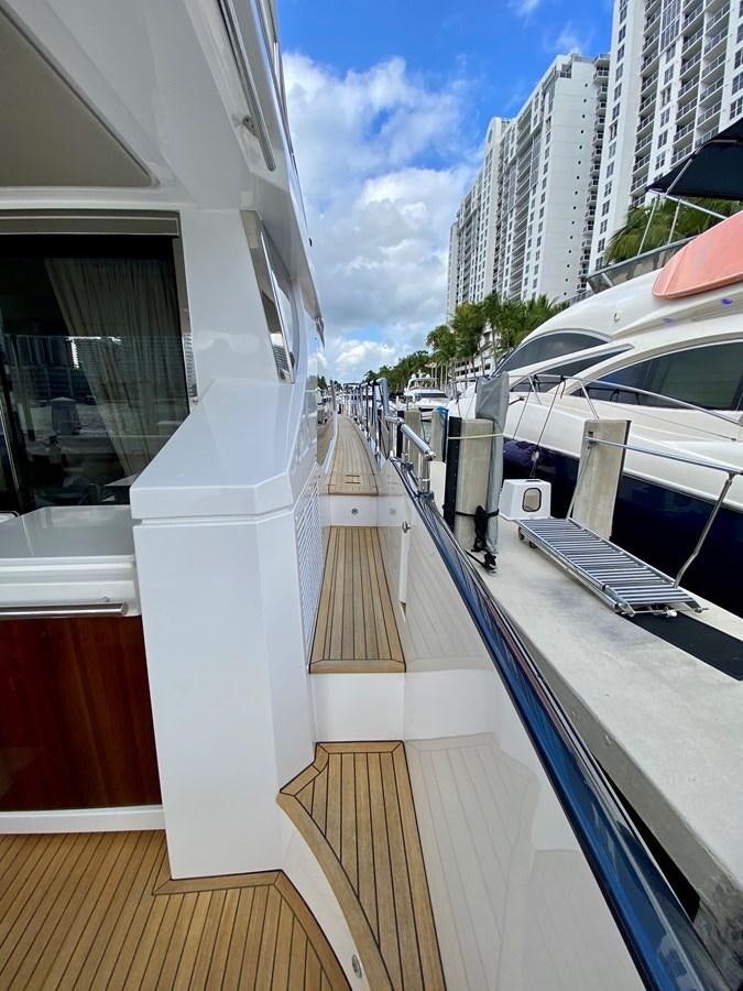 a deck with a boat and a person on it aboard SEARENITY II Yacht for Sale