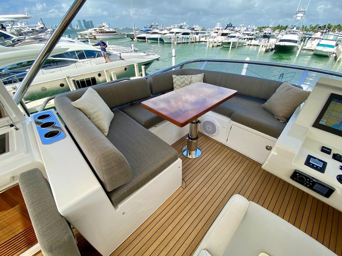 a room with a couch and a table with chairs on it aboard SEARENITY II Yacht for Sale