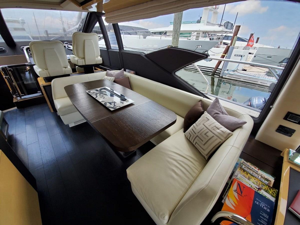 a room with a couch and a table with a laptop on it aboard SEARENITY II Yacht for Sale