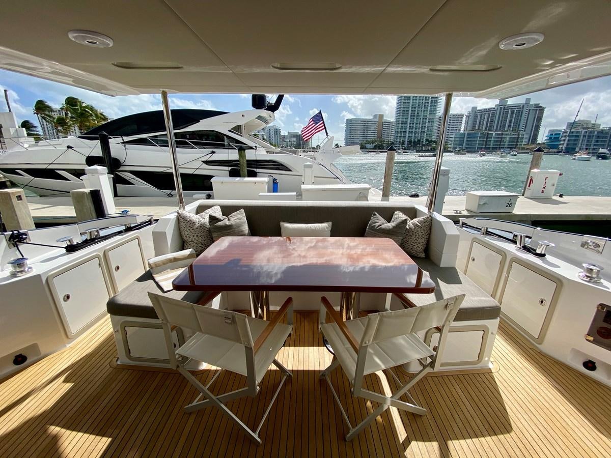 a room with a couch and a table with chairs aboard SEARENITY II Yacht for Sale