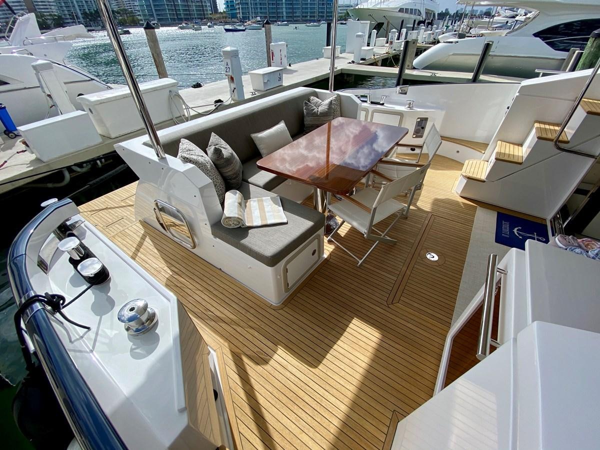 a room with a couch and a table with chairs on it aboard SEARENITY II Yacht for Sale