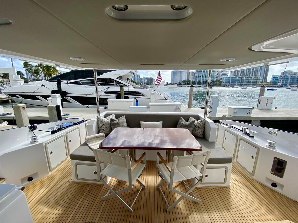 a room with a couch and a table with chairs aboard SEARENITY II Yacht for Sale