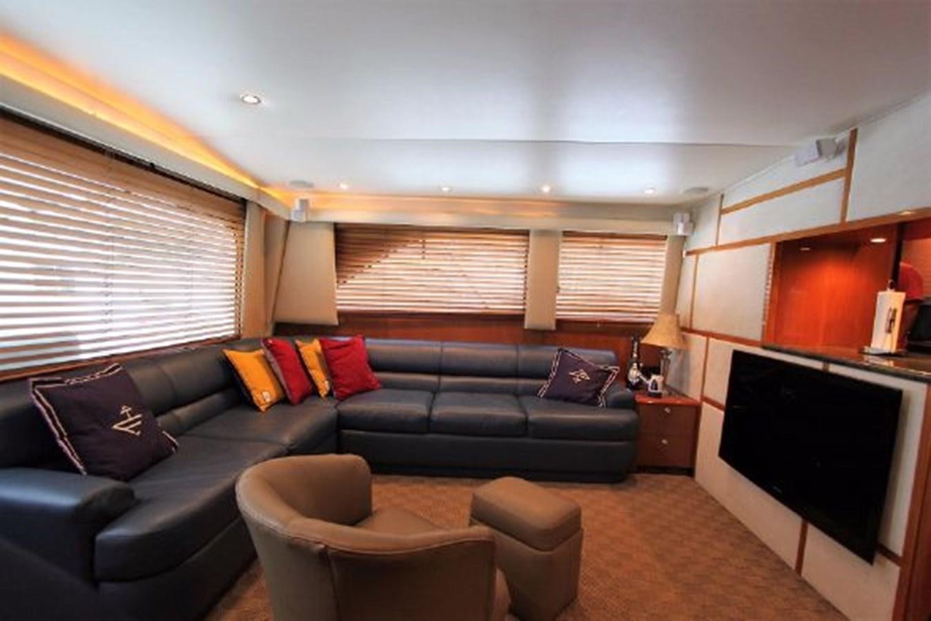 a living room with a black couch and a television aboard BROKYSTONE Yacht for Sale