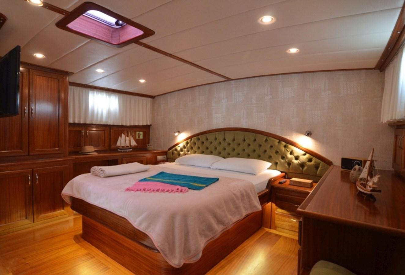 a bedroom with a bed and a desk aboard ZORBAS Yacht for Sale