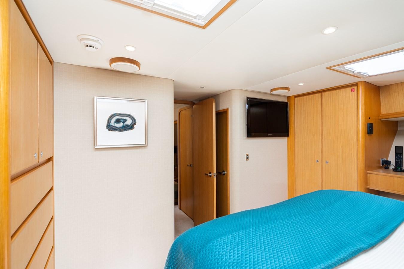 a bedroom with a blue bed aboard ESOTERIC Yacht for Sale