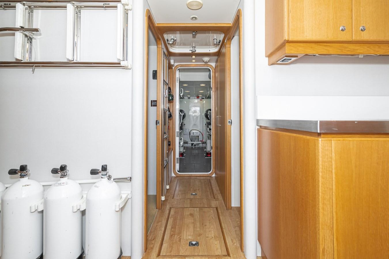 a kitchen with a white counter and wooden cabinets aboard ESOTERIC Yacht for Sale