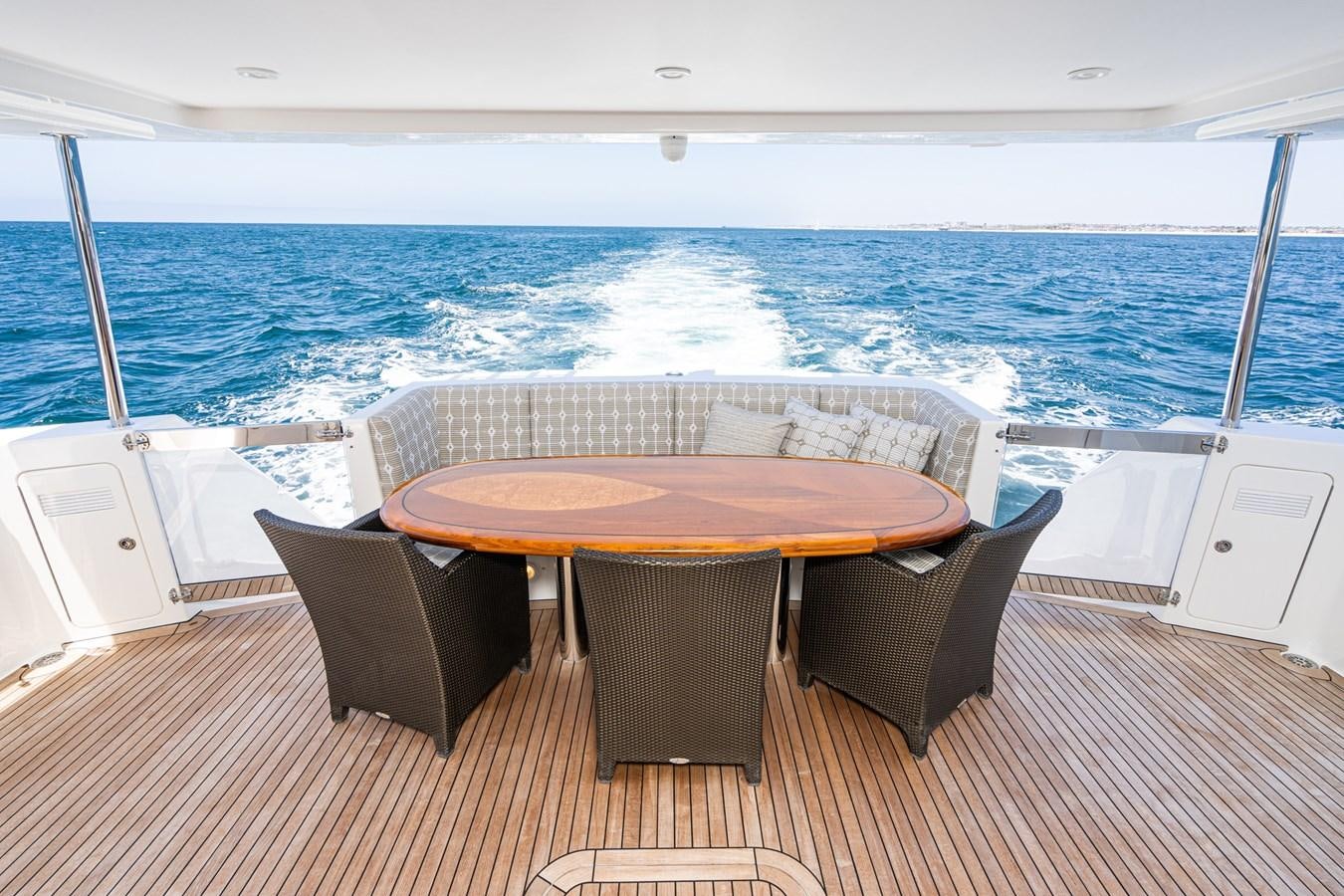 a table and chairs on a deck overlooking the ocean aboard ESOTERIC Yacht for Sale