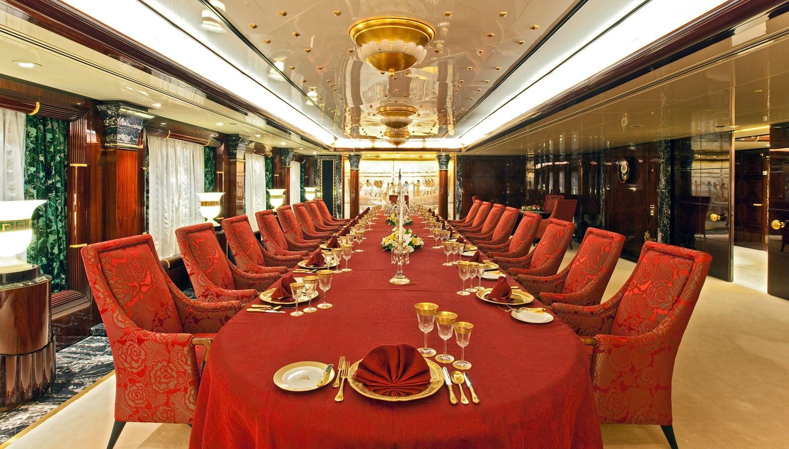 a large room with red chairs and tables aboard LADY MOURA Yacht for Sale
