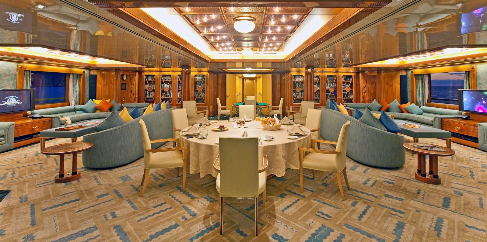 a room with a table chairs and a television aboard LADY MOURA Yacht for Sale