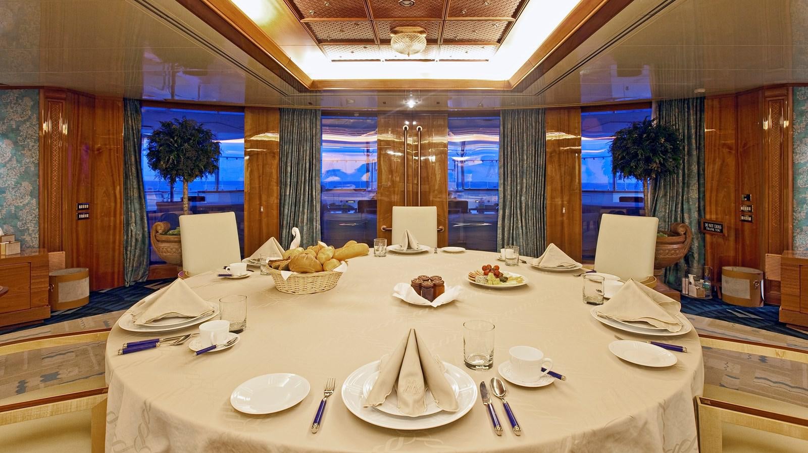 a large table with plates and chairs aboard LADY MOURA Yacht for Sale