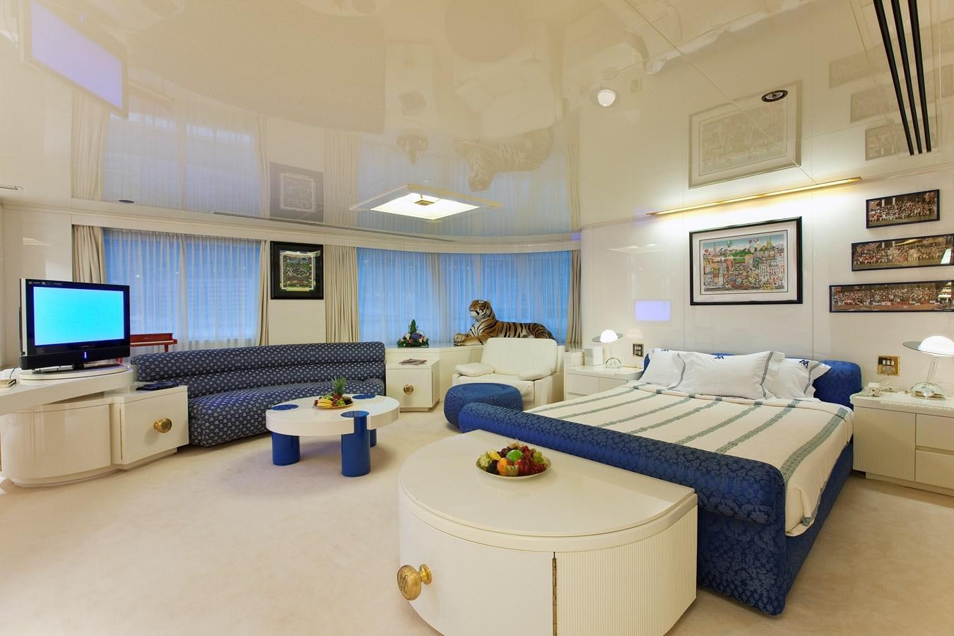 a bedroom with a blue couch and a white table aboard LADY MOURA Yacht for Sale