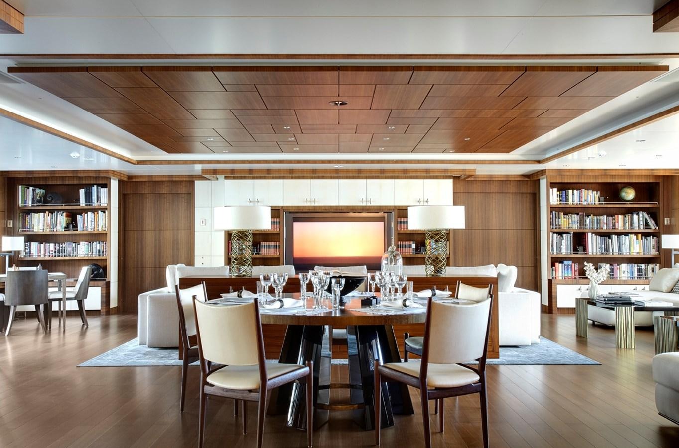 a room with a table and chairs aboard MAN OF STEEL Yacht for Sale