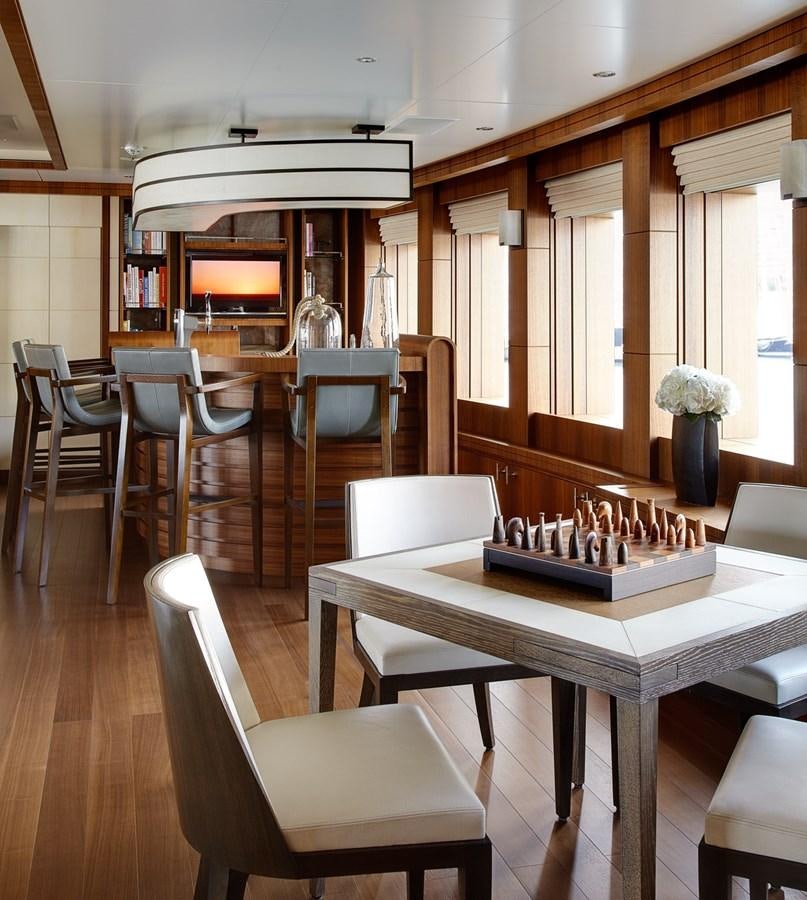 a room with tables and chairs aboard MAN OF STEEL Yacht for Sale