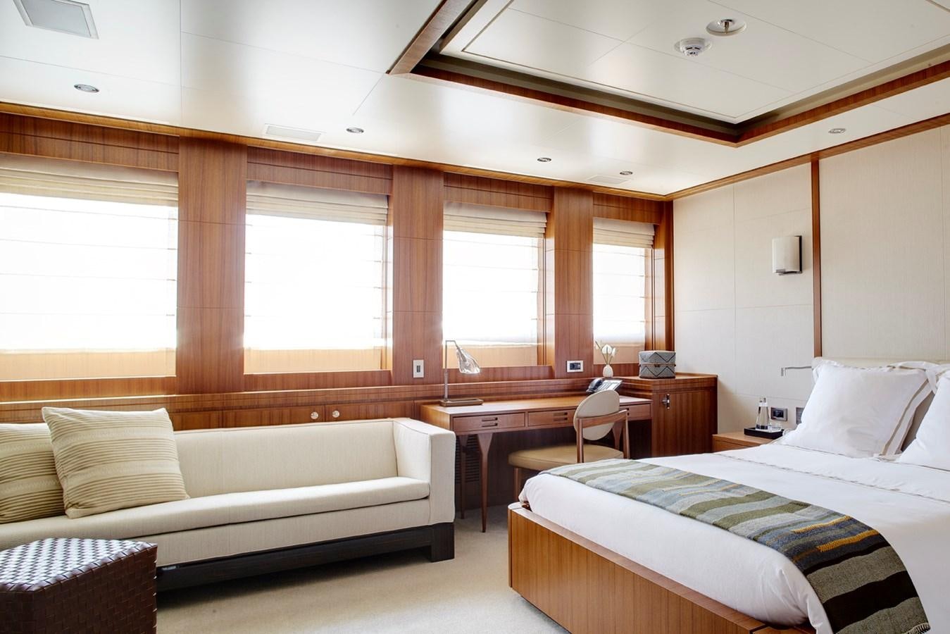 a room with a bed and a couch aboard MAN OF STEEL Yacht for Sale