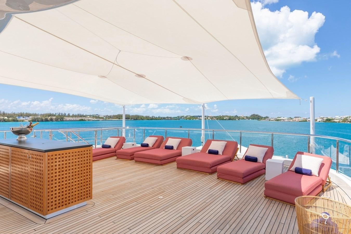 a deck with chairs and a large body of water aboard HBC Yacht for Charter