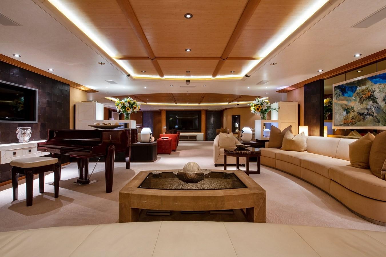 a living room with a piano and a large table aboard SUNRAYS Yacht for Charter