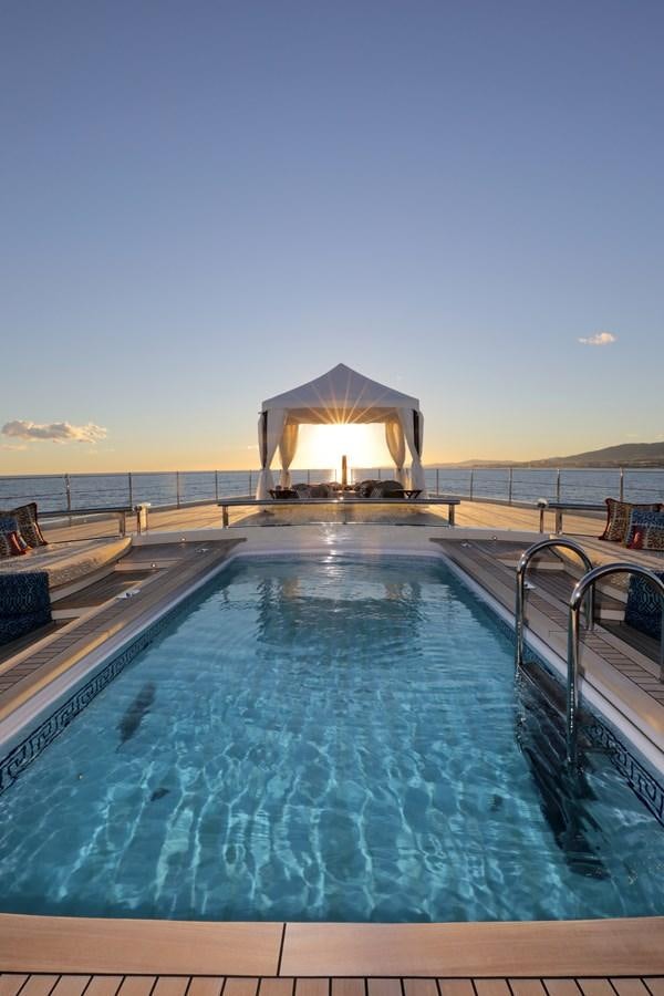 a pool with a large umbrella aboard EYE Yacht for Sale
