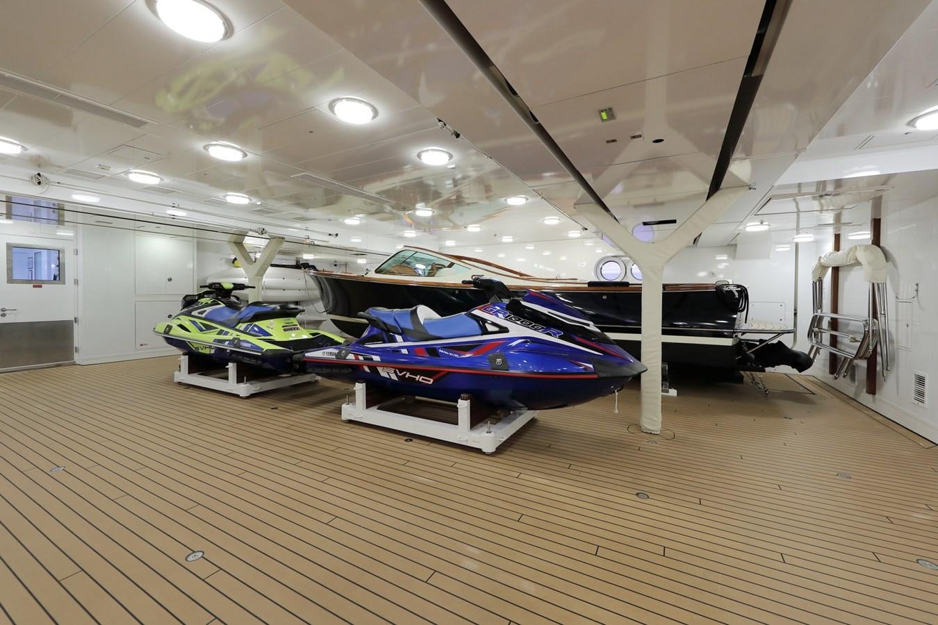 a large room with a couple of cars parked in it aboard EYE Yacht for Sale