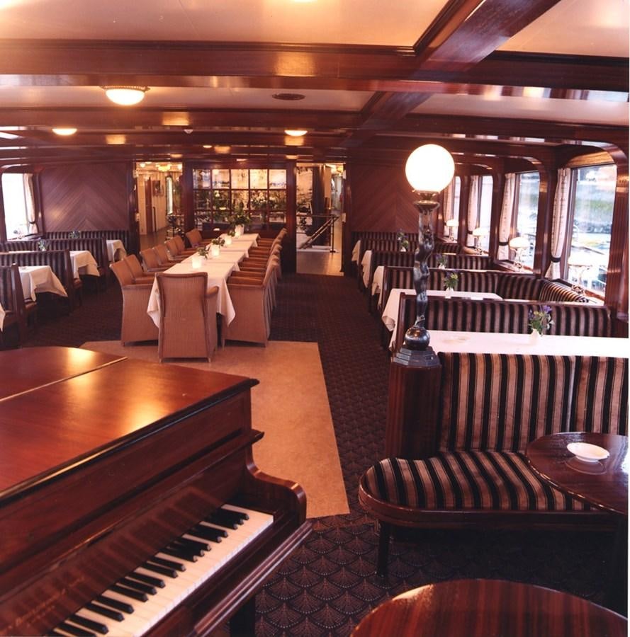 a room with a bar and a table aboard MAJESTEIT Yacht for Sale