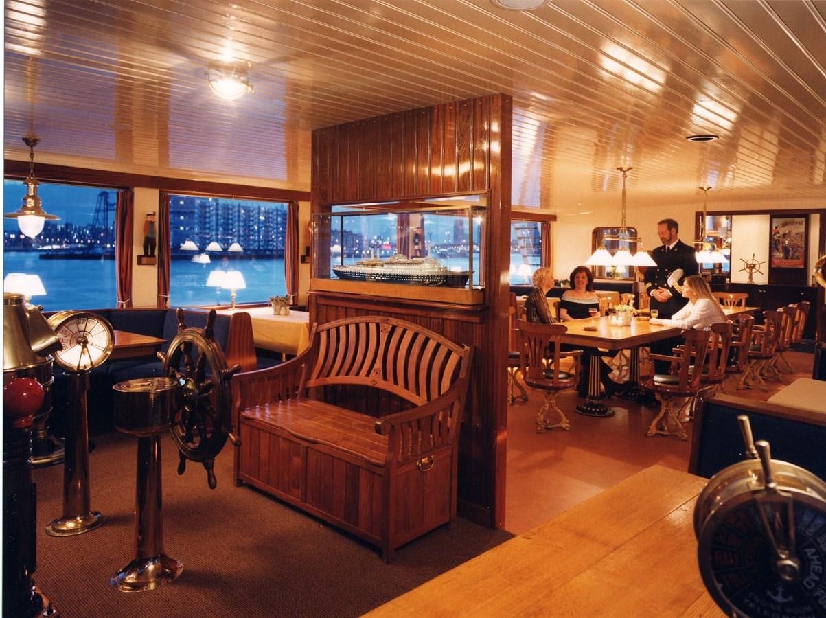 a room with tables and chairs aboard MAJESTEIT Yacht for Sale