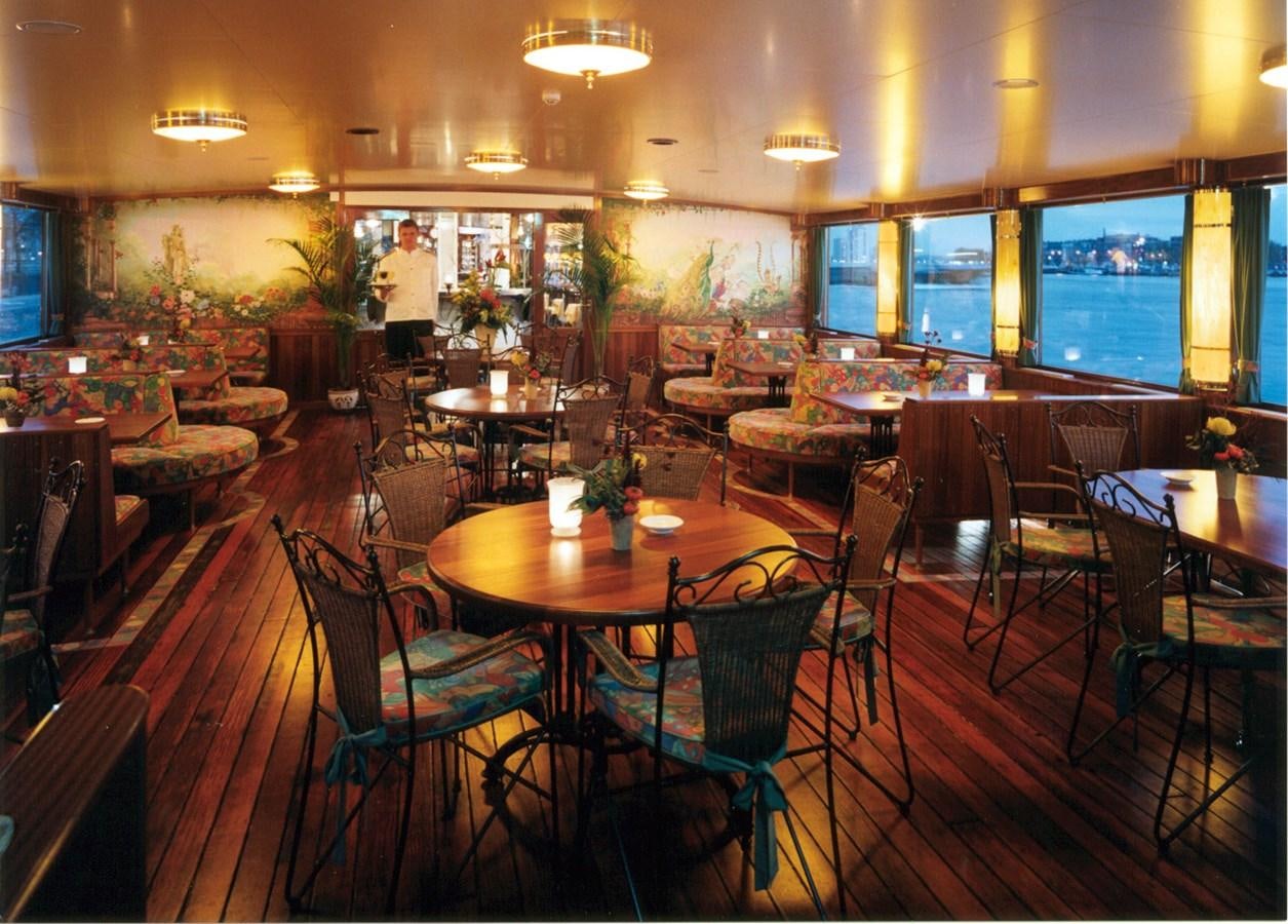 a restaurant with tables and chairs aboard MAJESTEIT Yacht for Sale