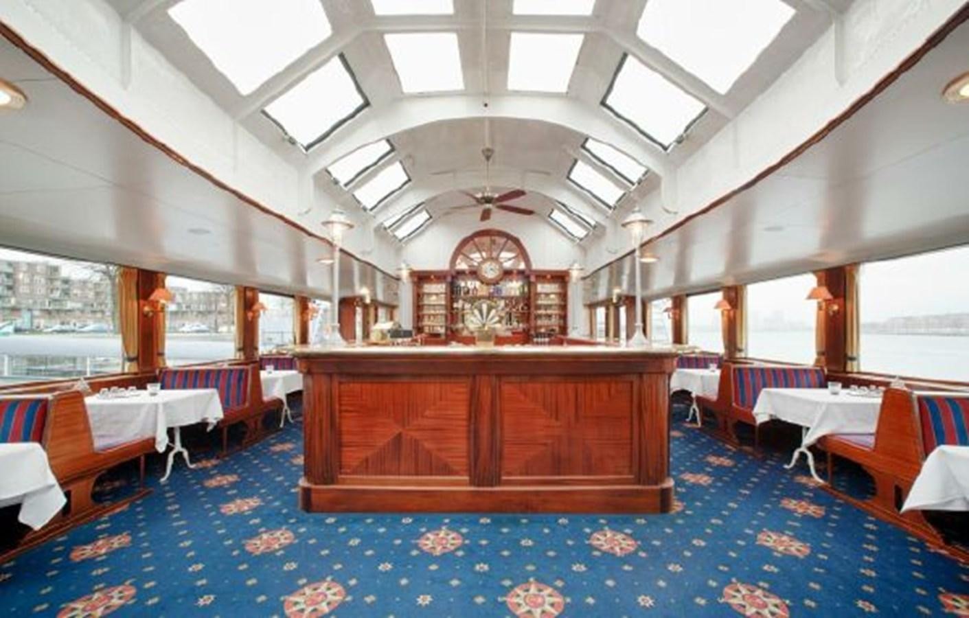a room with tables and chairs aboard MAJESTEIT Yacht for Sale