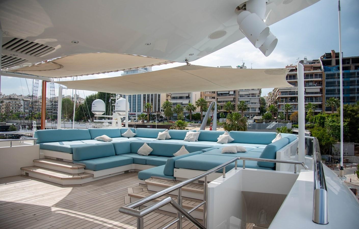 a pool with a deck and a building in the background aboard LADY VERA Yacht for Charter