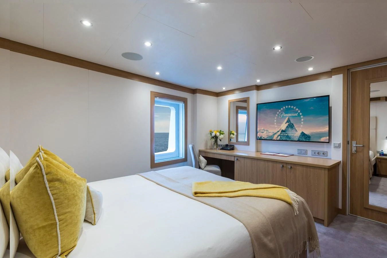 a bedroom with a tv on the wall aboard INDRATUS Yacht for Sale
