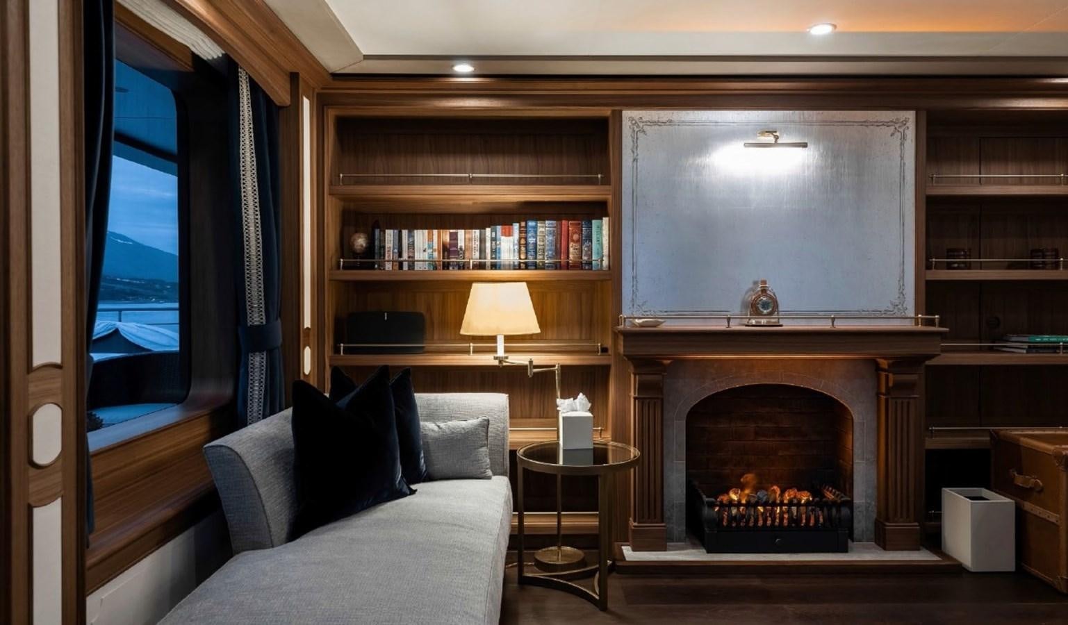 a living room with a fireplace aboard Q Yacht for Sale