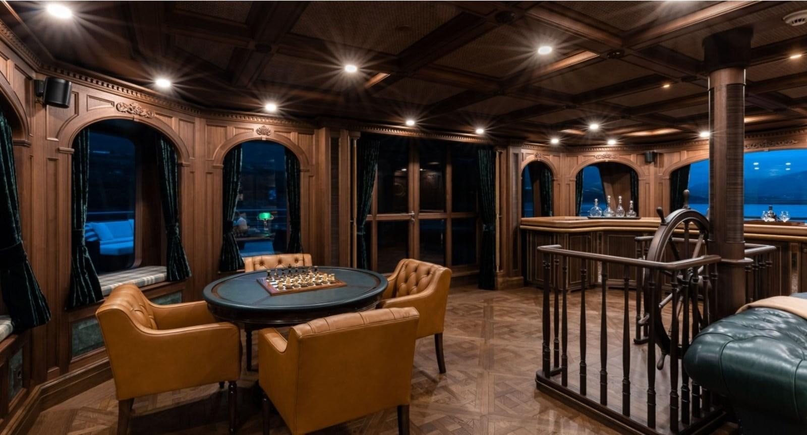 a room with a table and chairs aboard Q Yacht for Sale