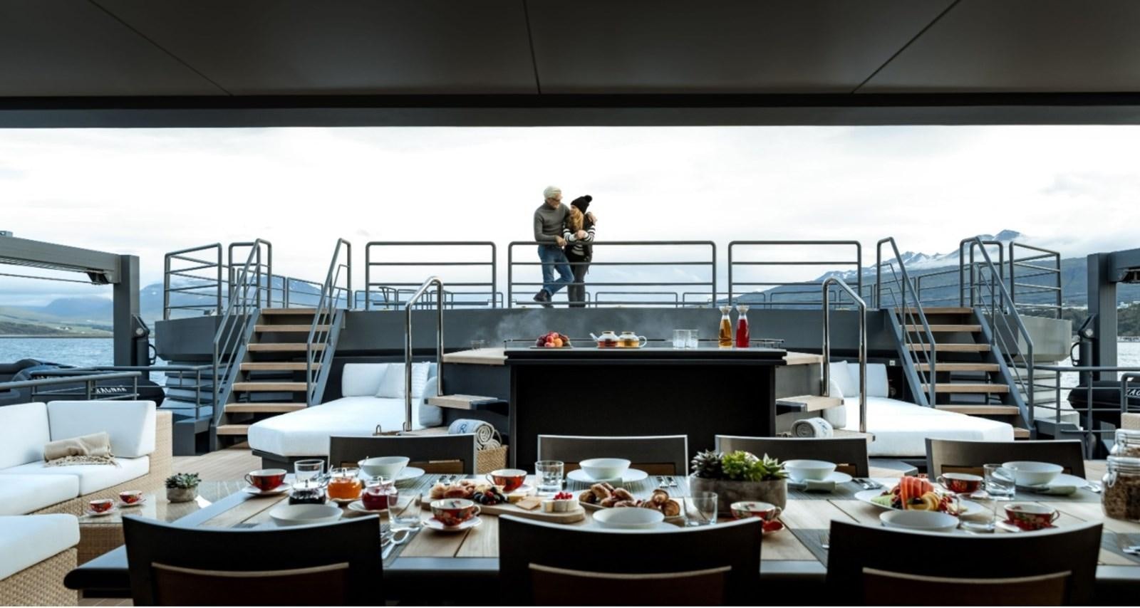 a room with a table and chairs aboard Q Yacht for Sale