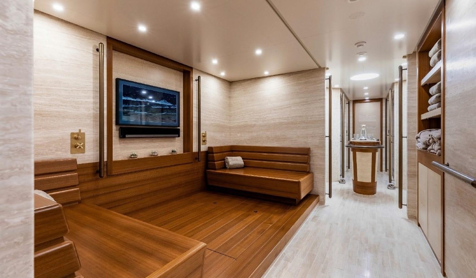 a room with a wood floor and a tv on the wall aboard Q Yacht for Sale