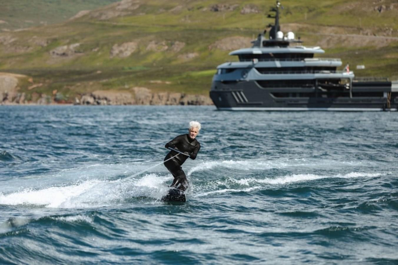 a man surfing in the sea aboard Q Yacht for Sale