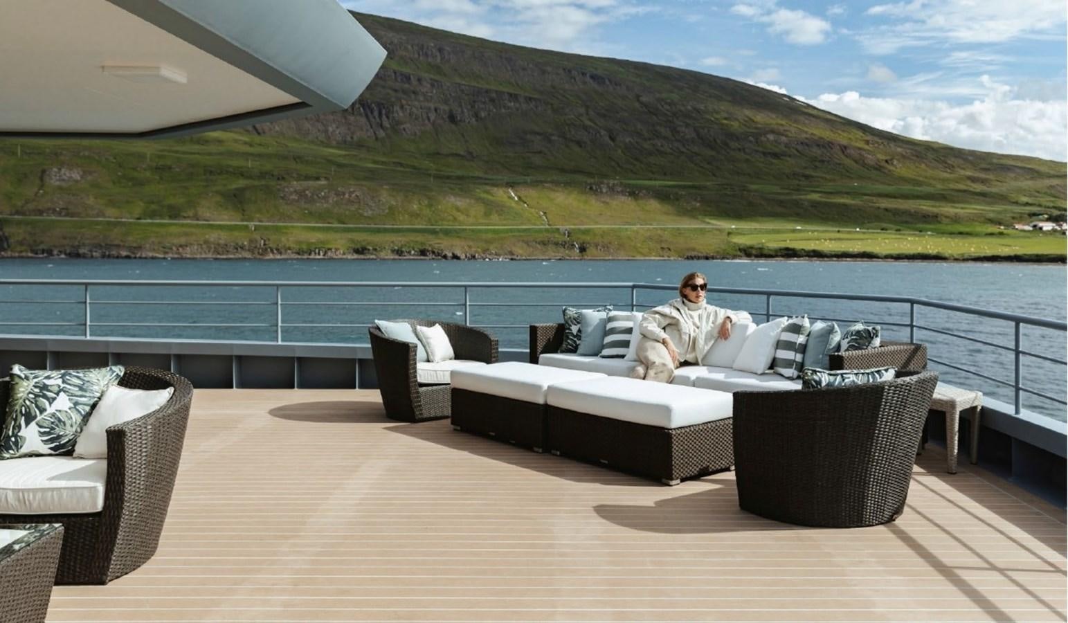 a person sitting on a couch aboard Q Yacht for Sale