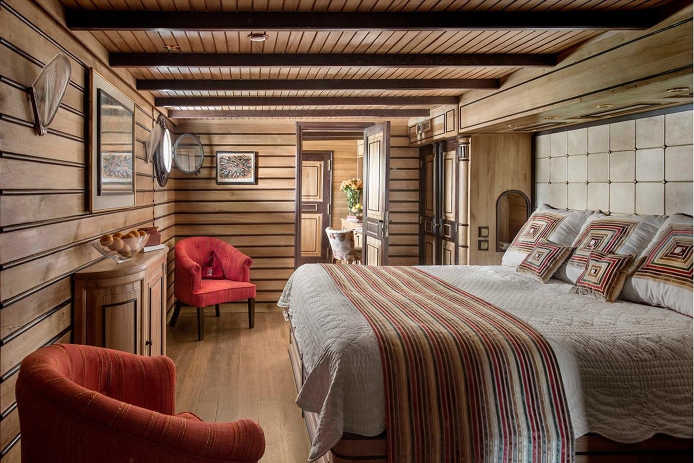 a bedroom with a bed and a chair aboard NORTH SEA Yacht for Sale