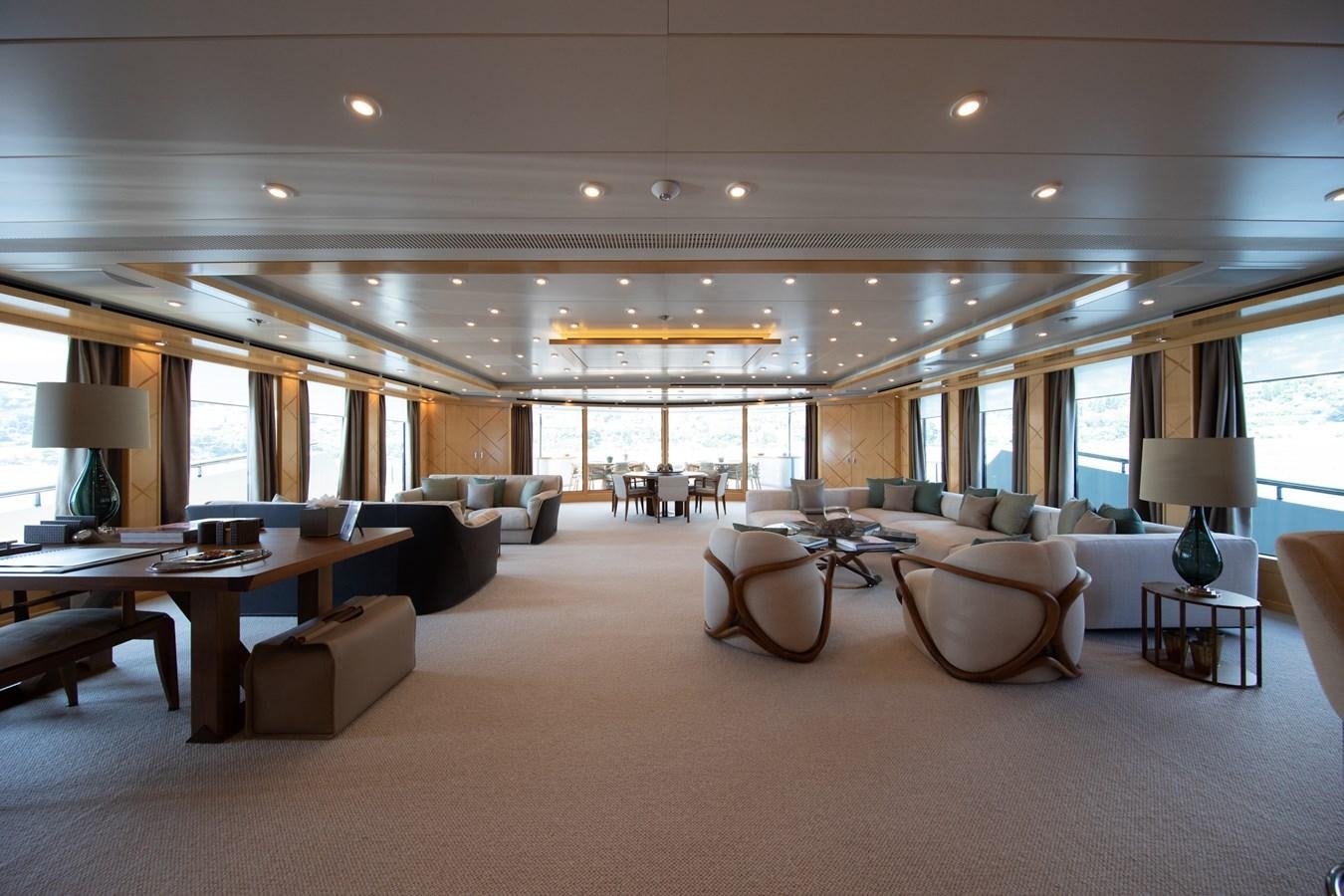 a large living room with a large table and chairs aboard AHS Yacht for Sale