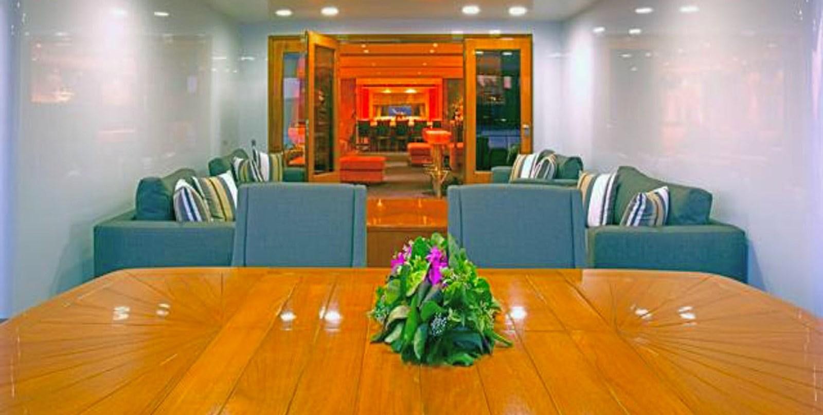 a living room with a wood table aboard ADAMAS V Yacht for Sale