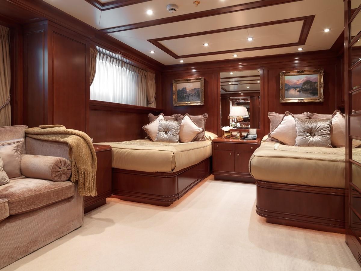 a room with a bed and a couch aboard APOGEE Yacht for Sale