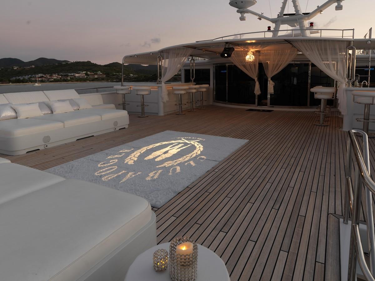 a deck with a pool and a plane in the background aboard APOGEE Yacht for Sale