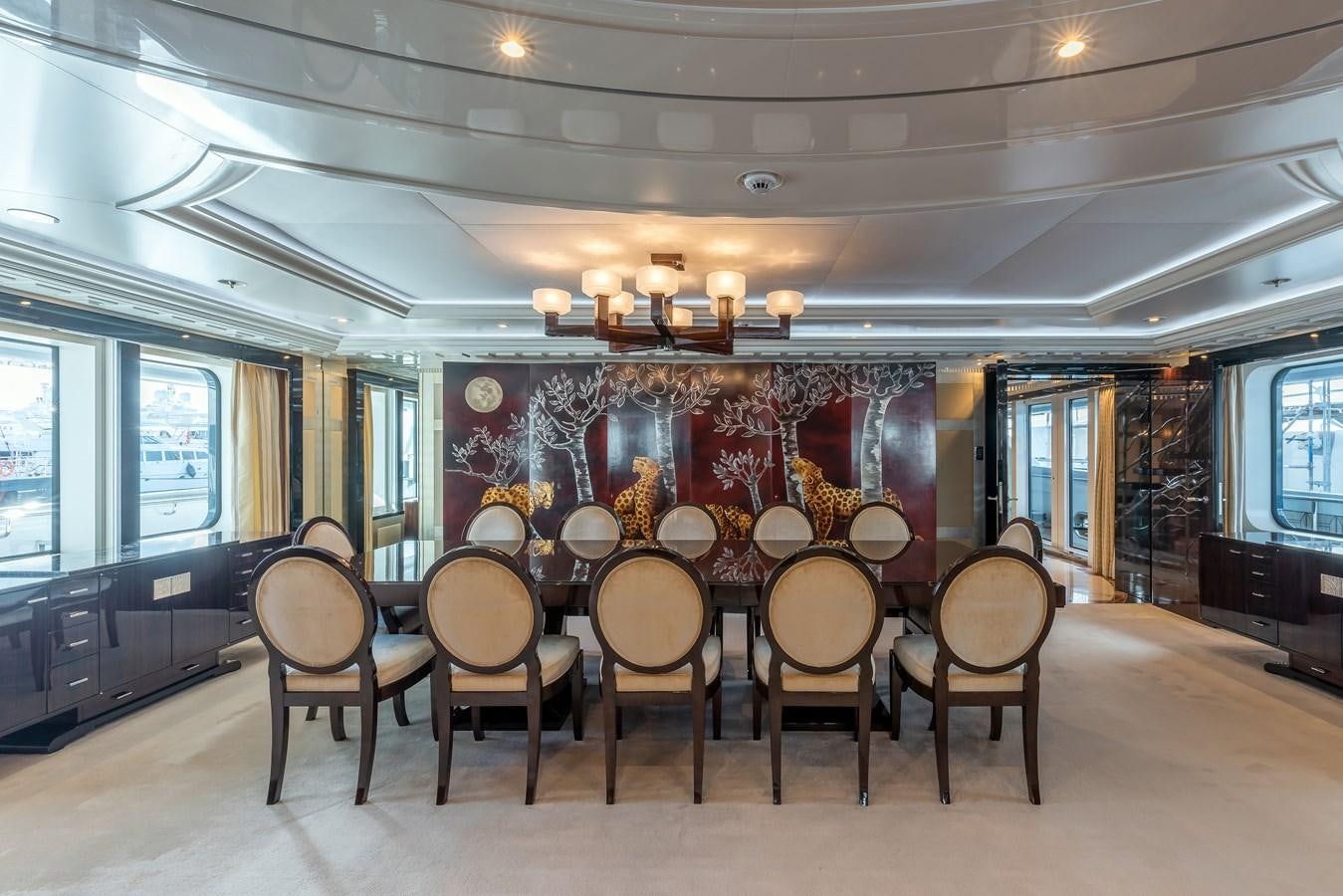 a room with a table chairs and a large painting on the wall aboard MARGUERITE Yacht for Sale