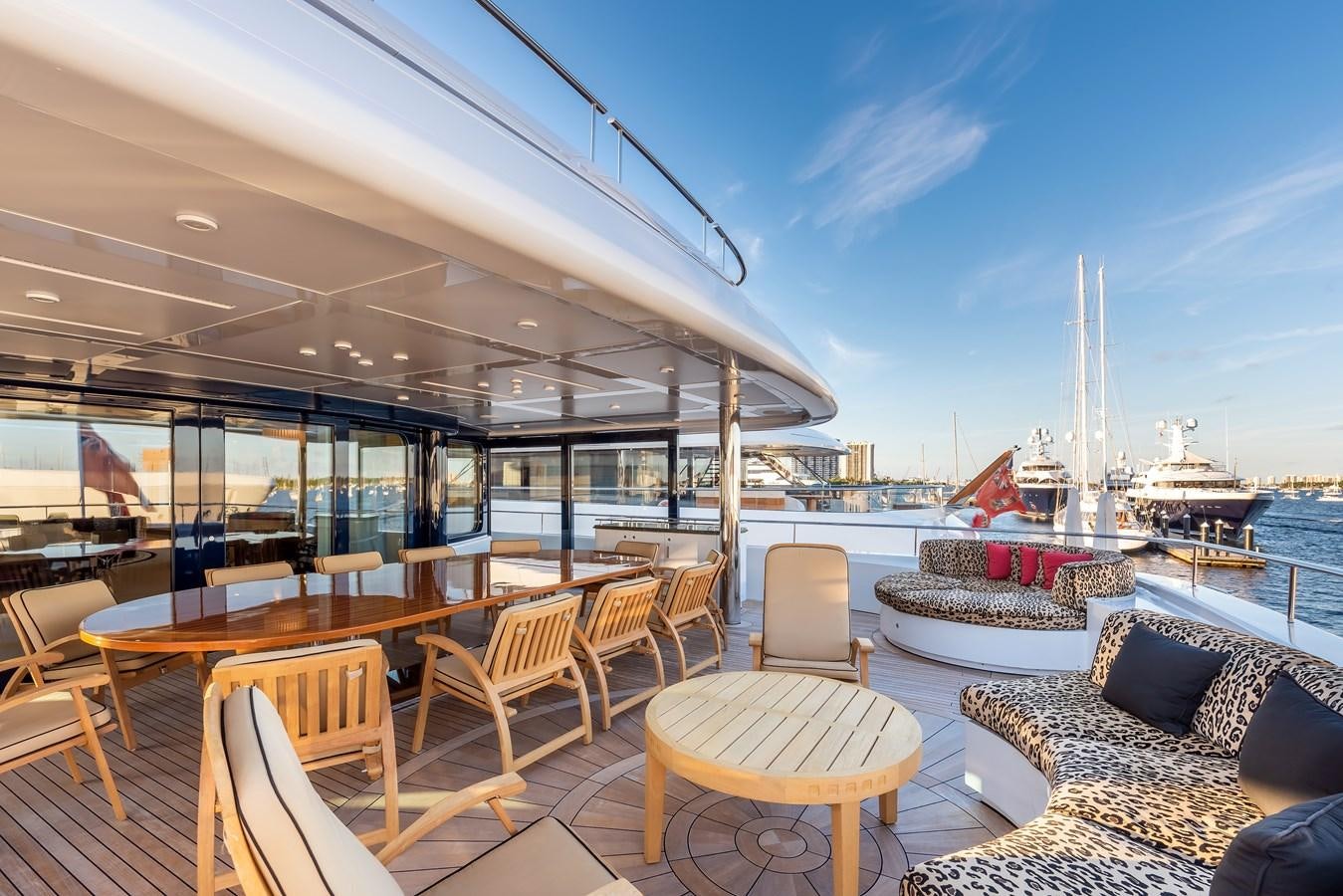 a room with a table chairs and a large boat in the water aboard MARGUERITE Yacht for Sale