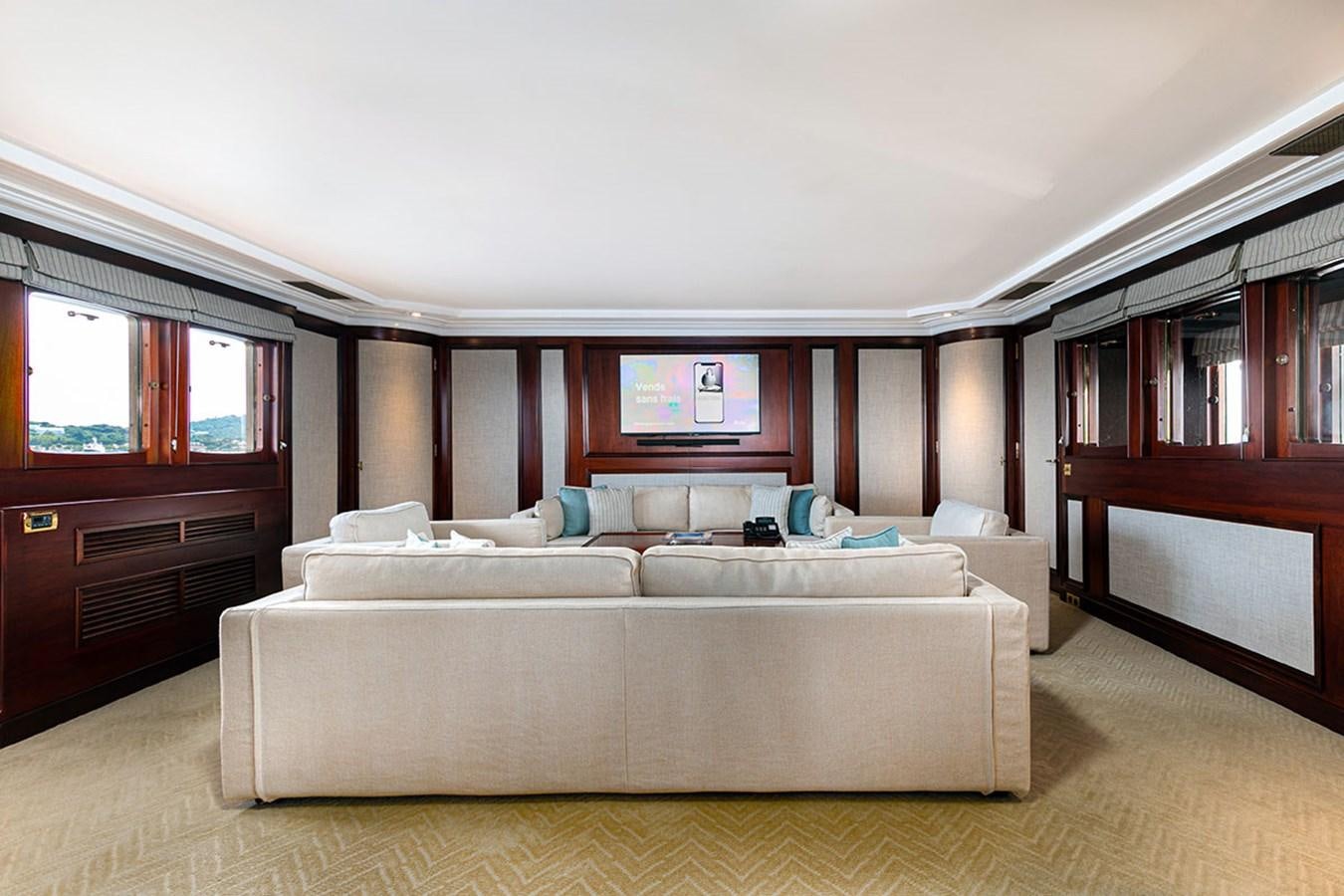 a large living room with a large couch and a wood cabinet aboard PALOMA Yacht for Sale
