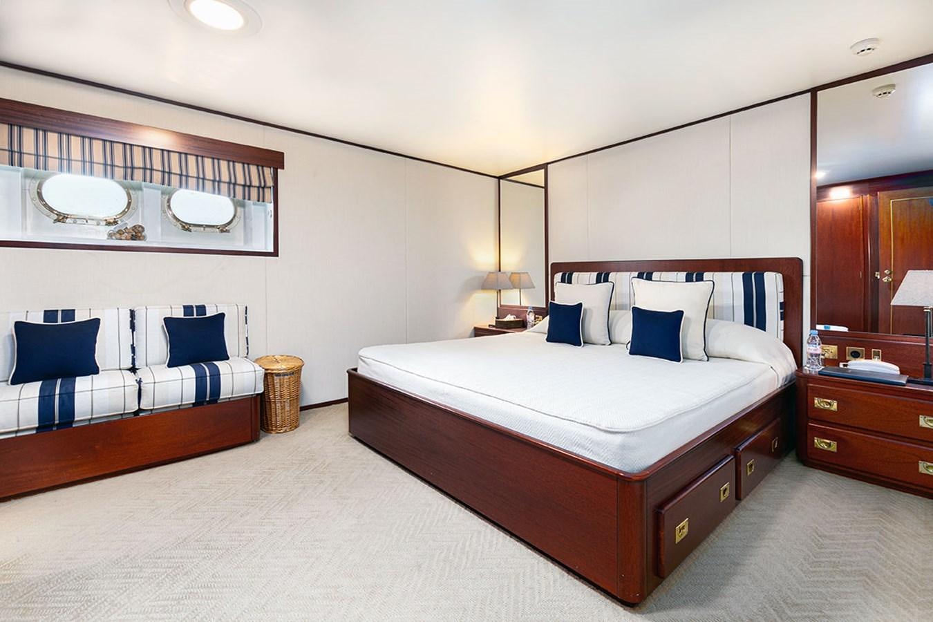 a bedroom with a bed and a mirror aboard PALOMA Yacht for Sale