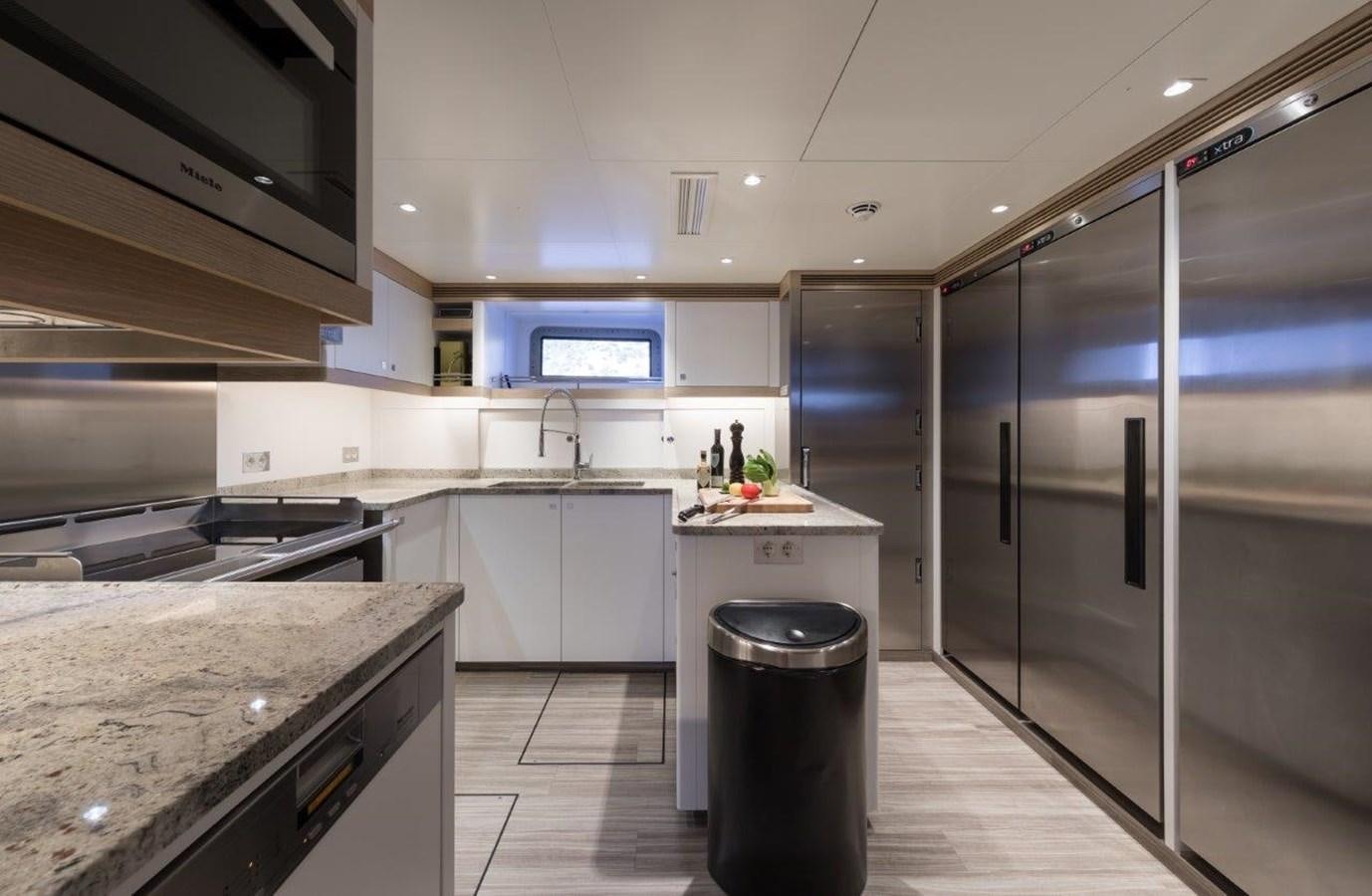 a kitchen with a stainless steel refrigerator aboard NGONI Yacht for Sale