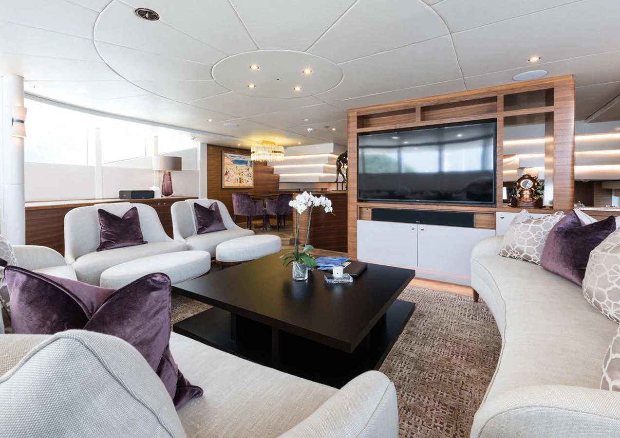 a living room with a tv and couches aboard LADY A Yacht for Sale