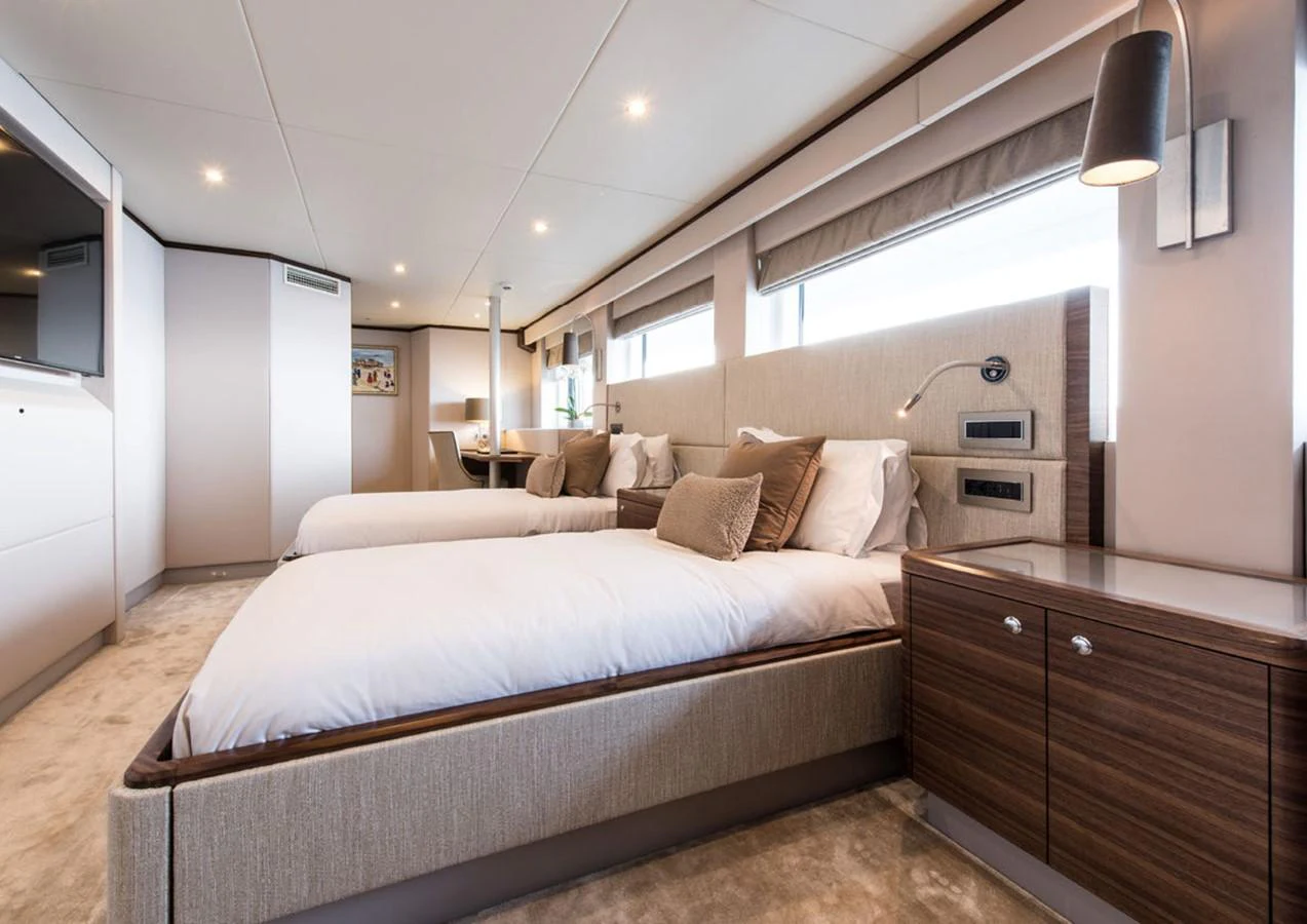 a bedroom with a bed and a dresser aboard LADY A Yacht for Sale
