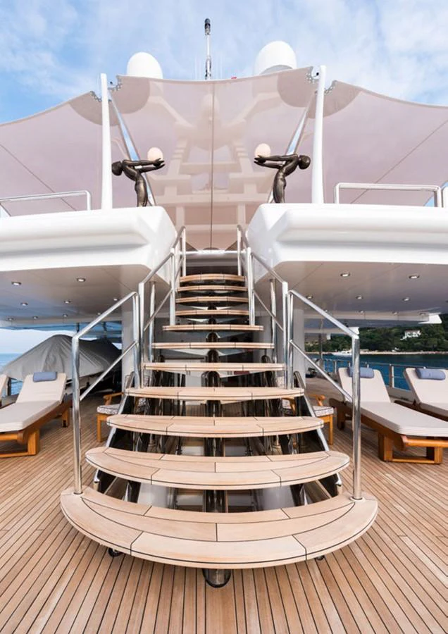 a deck with a staircase and a large building with a slide aboard LADY A Yacht for Sale